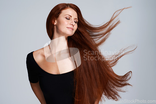 Image of Hair, beauty and woman in studio with wind for keratin treatment, wellness and haircare on gray background. Salon, hairdresser and face of ginger female model for shine, healthy and natural hairstyle