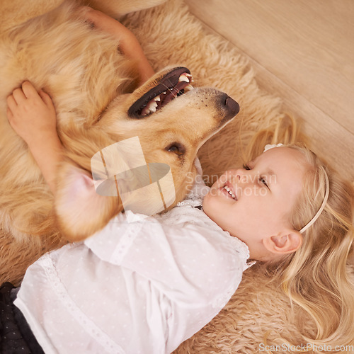 Image of Dog, girl and hug together on floor in living room and golden retriever, kid and playing with pet on lounge carpet. Young child, labrador and happiness or family home, pets and children from above