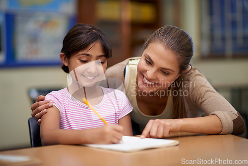 Image of School, education or scholarship with a student and teacher in a classroom together for writing or child development. Study, learning and teaching with a woman educator helping a girl child in class