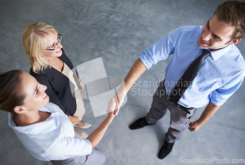 Image of Top view, handshake and happy business people in deal, thank you and partnership agreement. Teamwork, networking and shaking hands in collaboration, welcome and support of promotion, trust or success