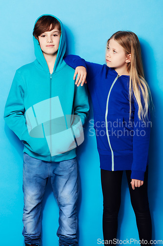 Image of Fashion, portrait and teenager models in a studio with a casual, cool and stylish outfit. Youth, friendship and young boy and girl posing together with trendy apparel style by a blue background.