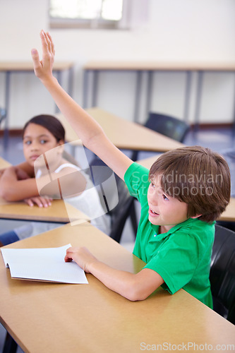 Image of Child raise his hand in school for questions, support and help with classroom education and teaching in school development. Clever boy or kid with arm up for knowledge, learning and answer or advice