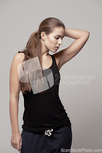 Image of Fashion, casual and woman in a studio with fitness apparel, outfit or clothes and confidence, isolated on grey studio background. Pose, natural beauty and female model with cool style or athleisure