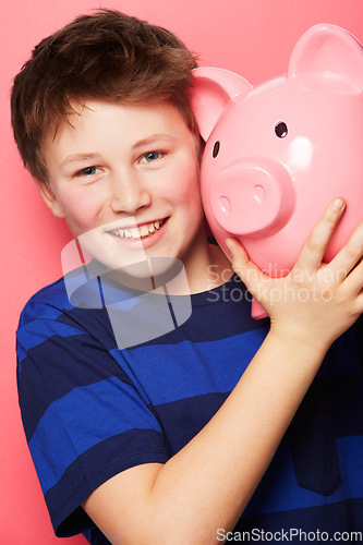 Image of Happy boy, portrait and piggy bank with smile for savings, money or coins against a pink studio background. Little child or kid holding piggybank and smiling for financial freedom, cash or investment