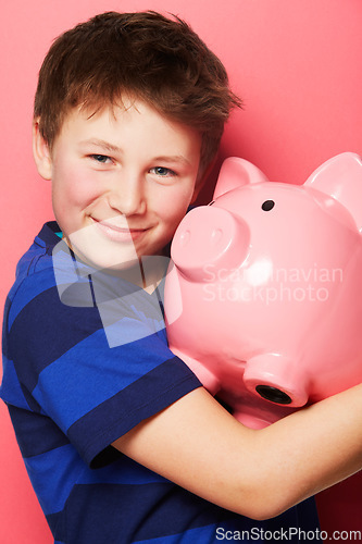 Image of Happy boy, portrait smile and piggy bank for investment, savings or coins against a pink background. Little child or kid holding piggybank and smiling for financial freedom, money or growth in profit
