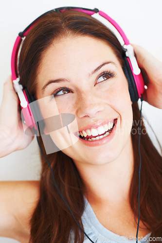 Image of Music headphones, face and happy woman listening to fun girl song, wellness audio podcast or radio sound. Studio smile, freedom and gen z model streaming edm playlist isolated on white background