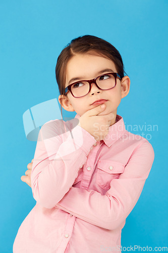 Image of Thinking, ideas and girl with decision, choice and happiness against a blue studio background. Female child, kid and young person with glasses, thoughts and wonder with information, future and geek