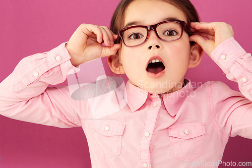 Image of Portrait, shocked and girl child with glasses in studio isolated on a pink background. Kid, nerd and face of surprised person, wow or omg, emoji or reaction to unexpected news, announcement or secret