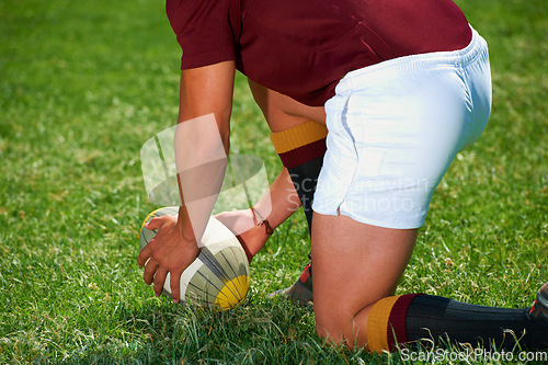 Image of Hands, rugby and closeup of a man with a ball outdoor on a pitch for action, goal or start. Male athlete person playing in sport competition, game or training for fitness, workout or exercise to kick