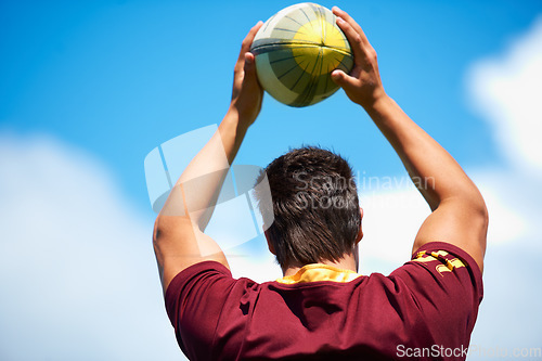 Image of Rugby, sports and man throw ball outdoor on a pitch with blue sky for goal. Headshot of male athlete person playing in sport competition, game or training for fitness, workout or exercise from behind