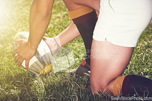 Image of Rugby, hands closeup and man with a ball outdoor on a pitch for action, goal or start. Male athlete person playing in sport competition, game or training for fitness, workout or exercise on grass