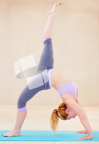 Image of Fitness, yoga and woman stretching legs on mat for flexibility, wellness and balance in studio. Sports, healthy workout and female person in gym class for exercise training and pilates in wheel pose