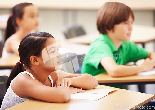 Image of Education, students and girl in classroom with focus, attention and study at Montessori school. Children at desk studying with notebook, child development and kid with concentration in lesson or test