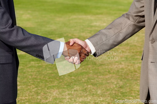 Image of Closeup, shaking hands and business men on grass for b2b agreement, welcome and teamwork. Businessman, hand shake and collaboration for goal, deal or together for meeting, partnership or thank you