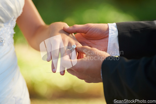 Image of Closeup, wedding and hands with a ring, love ceremony and commitment with partnership, religious ritual and marriage. Zoom, couple or bride with groom, jewellery or relationship with romance or trust