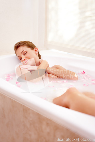 Image of Woman portrait, rose and milk bath with flower petals and luxury bathroom treatment. Beauty body care, cleaning and female person relax in home with floral aromatherapy and natural wellness wash