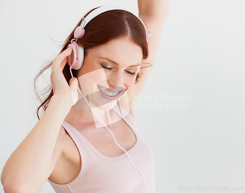 Image of Happy woman, dance and headphones in white background, isolated studio and freedom of celebration, good mood and energy. Excited female model, dancing and listening to music, audio and radio sound