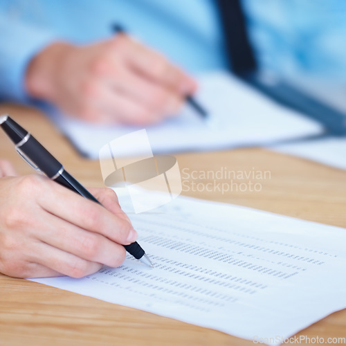 Image of Business people, hands and writing on finance spreadsheet for accounting, budget or expenses on form. Hand of accountants working on financial report, documents or paperwork with pen on office desk