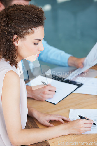 Image of Business woman, writing and documents in meeting for finance, accounting or planning budget on office desk. Female accountant working on financial report, paperwork or accounts with pen at workplace