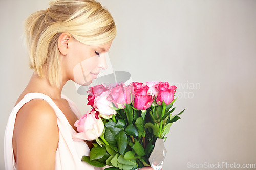 Image of Bouquet, woman and roses in studio for valentines day, gift or thank you gesture on grey background. Fresh, rose and girl with flowers, happy and relax with floral arrangement and copy space