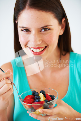 Image of Woman, portrait and eating a healthy fruit salad with berries, nutrition and health benefits. Face of a happy female person on nutritionist diet with vegan food for weight loss, wellness or detox