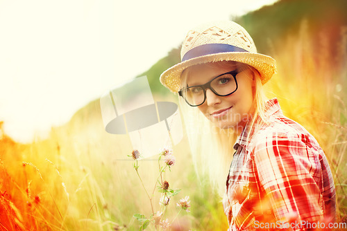 Image of Field, countryside and portrait of woman with flowers for freedom, wellness and fresh air outdoors. Nature, summer and lens flare for female person in wild meadow for relaxing, calm and peace morning