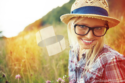 Image of Lens flare, countryside and portrait of happy woman in field for freedom, wellness and sustainability outdoor. Nature, summer and face of hipster person in meadow with glasses, fashion and style