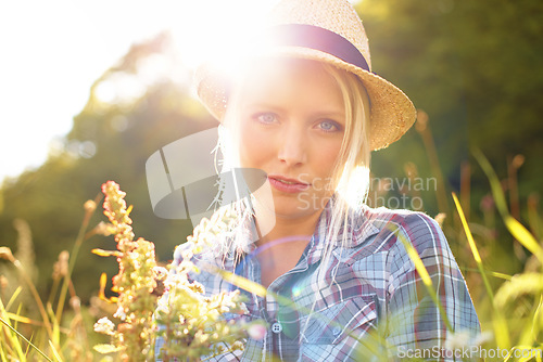 Image of Lens flare, countryside and portrait of woman with sun in field for freedom, wellness and relax. Nature, hipster and face of female person in flower meadow for sustainability and ecology in summer