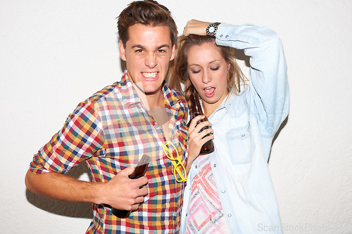 Image of Portrait of gen z couple at party, beer and drunk face, hipster fashion with university youth culture. Drinks, woman and man in crazy picture at college event, happy friends on white wall background.