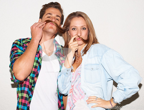 Image of Funny portrait of cool couple with goofy face, gen z fashion and university culture with crazy hipster youth. Happiness, woman and man with fun at college, hair moustache on white wall background.