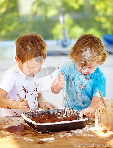 Image of Baking, kids and messy friends in the kitchen together, having fun with ingredients while cooking. Children, food and bake with naughty young brother siblings making a mess on a counter in their home