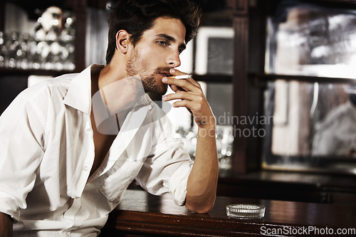 Image of Handsome man, smoking and on bar counter or cigarette burning on hand and thinking about cancer. Sexy, male person face or with ash tray or customer relaxing with nicotine and smoke idea after work