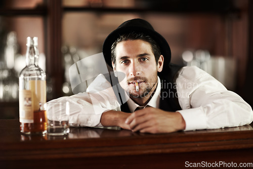 Image of Bartender man, portrait and smoke cigarette at party, club or event with bottle for drink service. Male server, barman or waiter with glass, alcohol or whiskey to relax after work at restaurant job