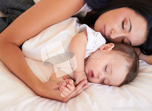 Image of Baby, sleeping and mother holding hands on bed with parent support, care and love. Relax, home and child sleep with mom in a house feeling tired and sleepy with mama rest with kid dreaming together