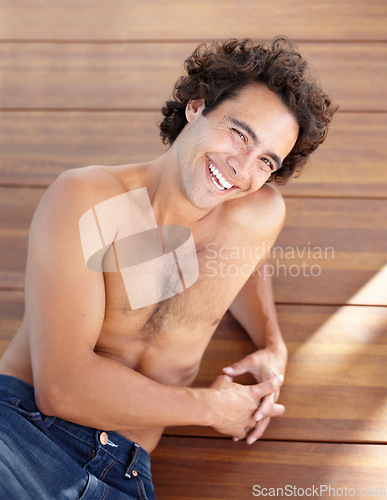 Image of Shirtless man, portrait and happpy guy in jeans laying down on wood floor with happy and sexy smile. Attractive, healthy and topless male laughing with relaxing, rest and bare chest in sunshine