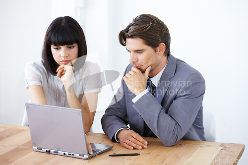 Image of Business people, laptop and thinking in meeting for strategy, planning or brainstorming decision at the office. Thoughtful businessman or woman wondering in team project plan on computer at workplace