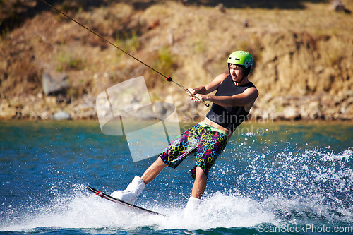 Image of Splash, surf and wakeboarding with man in lake for extreme sports, summer break and travel vacation. Wave, adrenaline junkie and fitness with guy skiing on river for health, adventure and speed