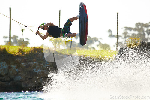 Image of Training, wakeboard and extreme sports with man in lake for action, summer break and travel vacation. Wave, adrenaline junkie and fitness with guy surfing on river for health, adventure and speed