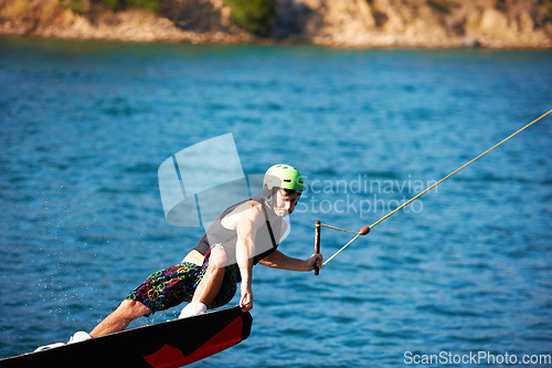 Image of Wakeboarding, fitness and water sports with man in lake for action, summer break and travel vacation. Wave, adrenaline junkie and training with guy surfing on river for health, adventure and speed