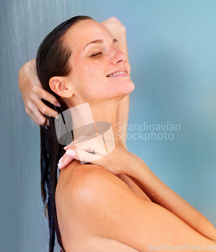 Image of Beauty, smile and skincare with woman in shower for bathroom, hygiene and grooming. Wellness, spa and dermatology with face of girl for washing hair, cleaning or hydration isolated on blue background