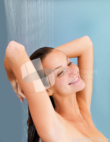 Image of Smile, skincare and happy with woman in shower for bathroom, hygiene and luxury. Wellness, spa and washing hair with face of girl for facial, cleaning and hydration isolated on blue background studio