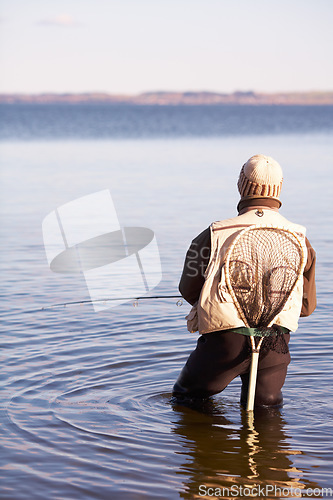 Image of Nature, peace and fishing with man in lake for summer break, hobby and relax on vacation. Sports, casting and gear with fisherman standing in freshwater pond for holiday, recreation and calm