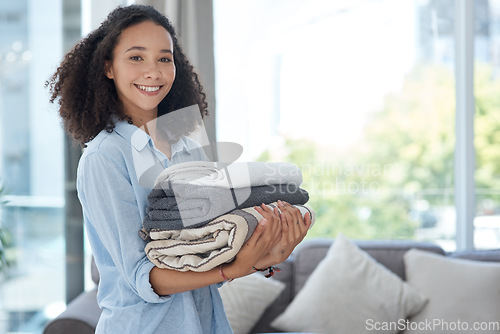 Image of Portrait, laundry and cleaning with an african woman in her apartment holding fresh towels during housework. Smile, fabric and washing with a happy young female cleaner in the living room of her home