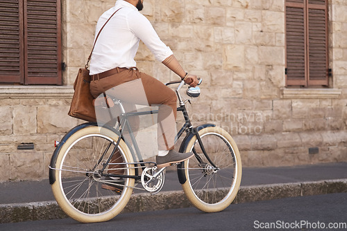 Image of Businessman, eco friendly and riding bicycle to work or corporate guy or commuter on urban street and in the morning. Traveling, male professional and carbon neutral bike to the office or transport
