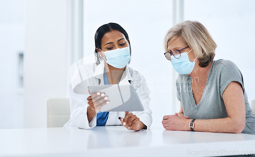 Image of Doctor, woman and tablet for covid consultation in hospital, talk and advice for healthcare, wellness and support. Medic, patient and face mask for ppe with digital touchscreen, results and feedback