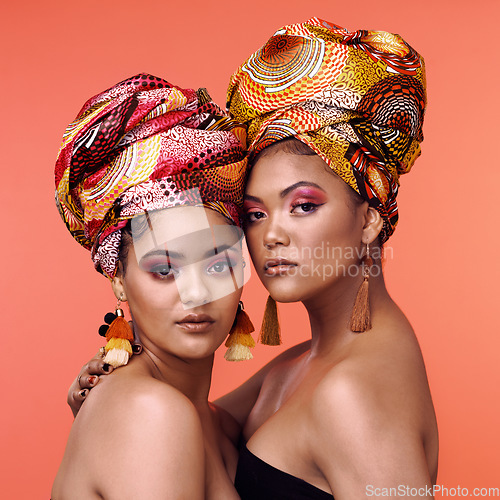 Image of African fashion, makeup and portrait of women on orange background for cosmetics, beauty and accessory. Glamour, designer and face of female people in exotic jewelry, luxury style and scarf in studio