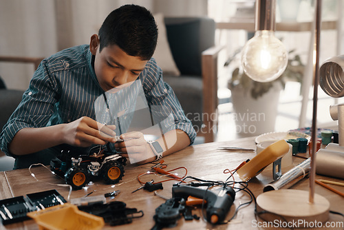 Image of Learning, car robot and kid in home with homework, homeschool and science for tech project. Robotics, building and boy child with electrical knowledge, engineering education and studying in house.