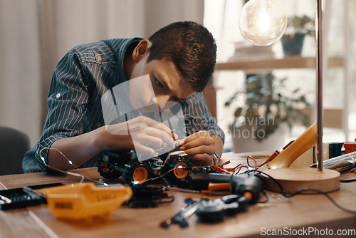 Image of Education, car robot and kid in home with homework, homeschool and science, learning and tech project. Robotics, building and boy child with electrical knowledge, engineering and studying in house.