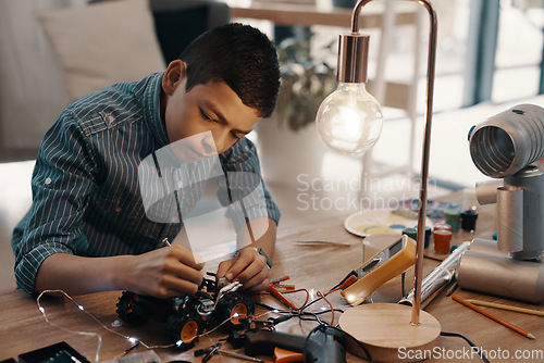 Image of Education, car robot and child in home with homework, homeschool and science, learning and tech project. Robotics, building and boy kid with electrical knowledge, engineering and studying in house.