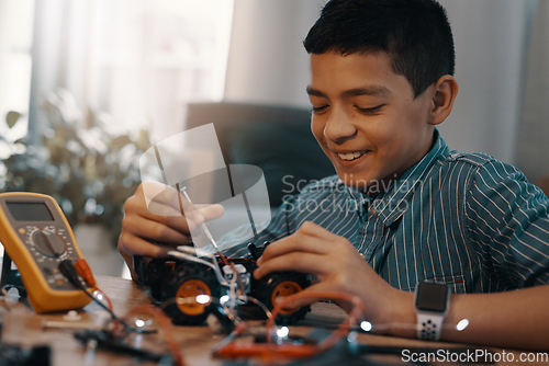 Image of Education, car robot and smile of child with homework, homeschool and science, learning and tech project. Robotics, building and boy kid with electrical knowledge, engineering and studying in house.